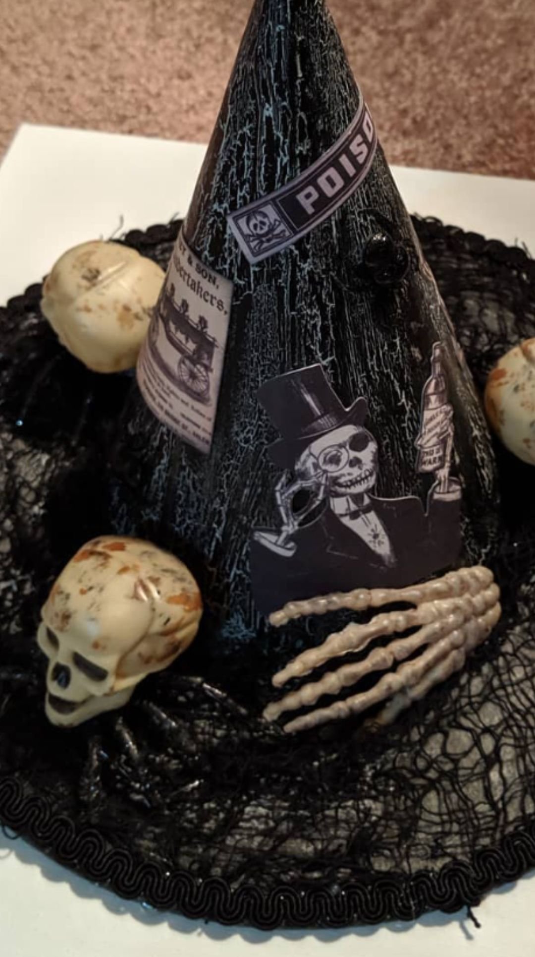 Witch hat Halloween centerpiece decorated with skeleton hands and potion labels