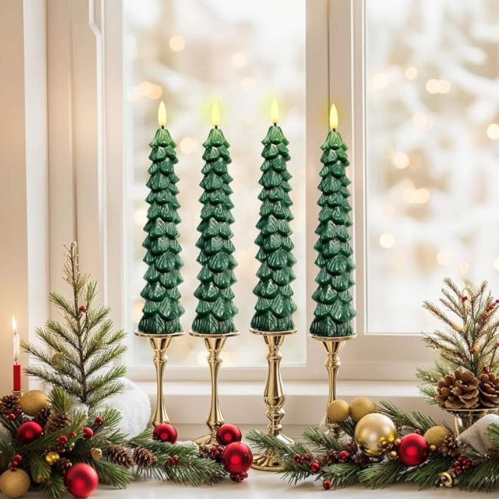 Green Christmas tree–shaped flameless candles displayed on a windowsill with festive greenery and ornaments, giving off a warm, cozy holiday glow.
