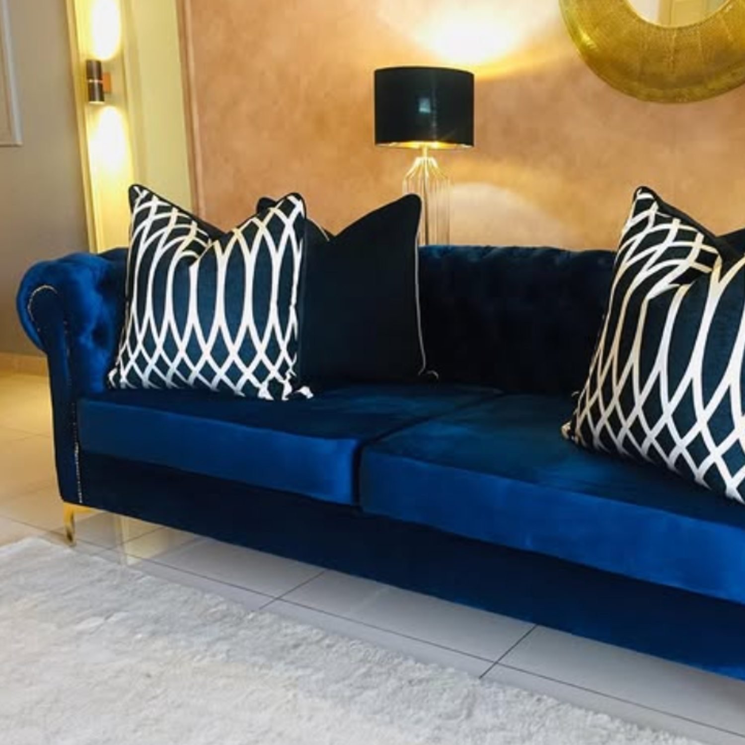 Navy velvet sofa with black and white patterned cushions in a contemporary interior.