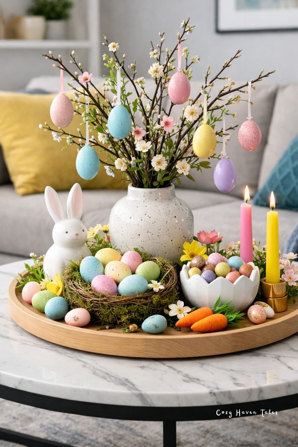 Round wooden tray with vase of egg branches and pastel eggs arranged as elegant easter table decor.