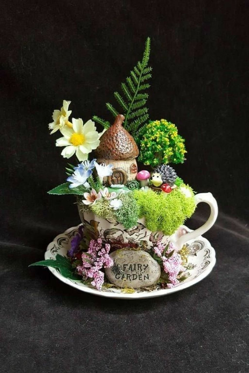 teacup floral arrangement with moss and decorative elements