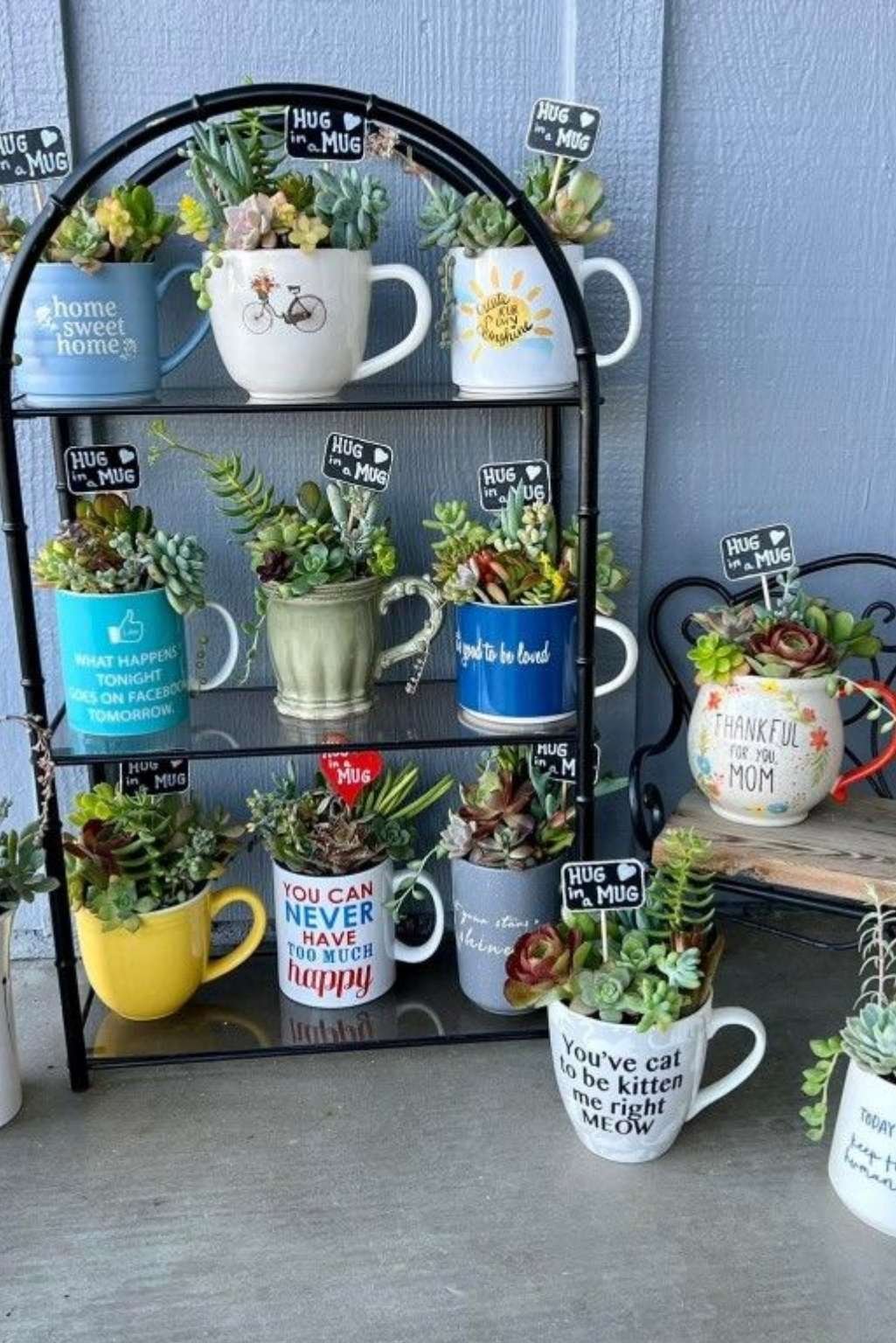 metal stand holding multiple colorful teacup planters