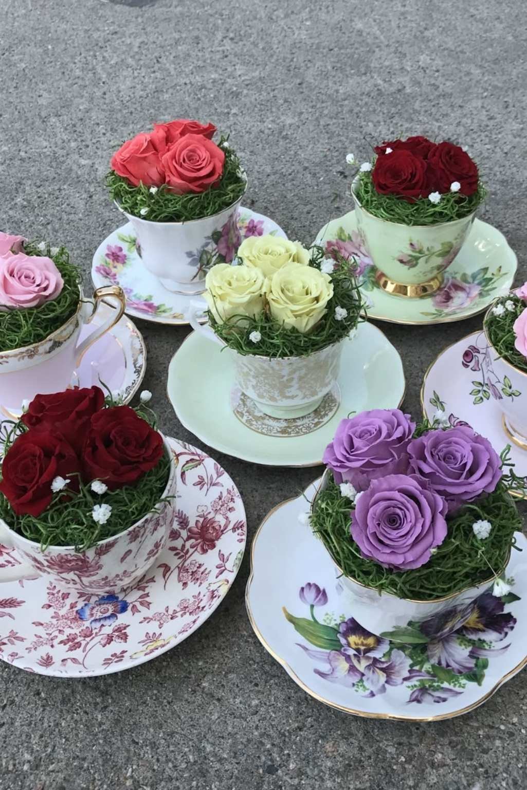 matching teacup planters filled with colorful flowers