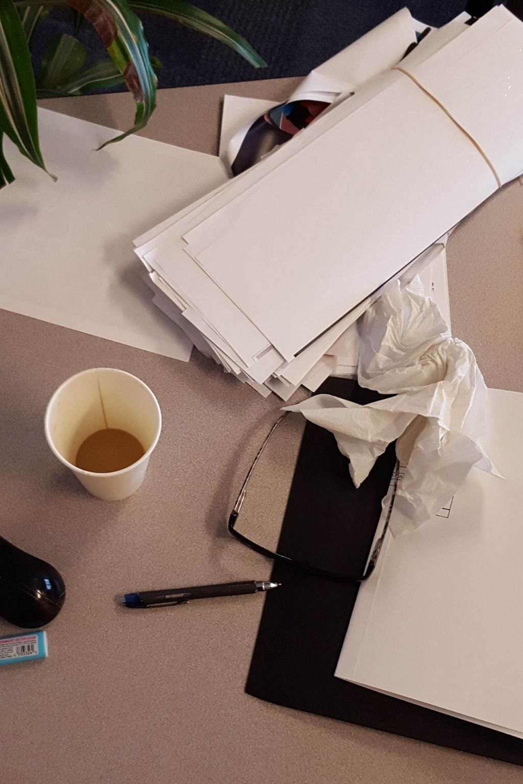 A cluttered desk with scattered papers and objects, reflecting one of the 7 red flags your home has too much stuff