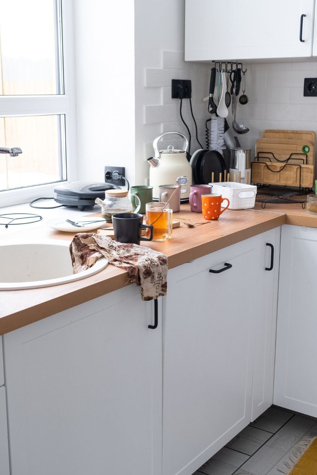 A crowded kitchen counter covered with appliances and items, one of the 7 red flags your home has too much stuff
